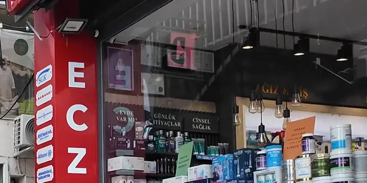Kırmızı eczane tabelası ve ilaç rafları