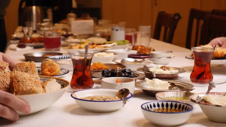 İnce belli bardakta çay ve kahvaltılıklarla kurulmuş kafe masası